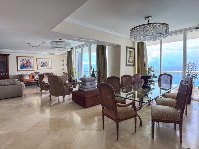 dining room featuring a notable chandelier, expansive windows, plenty of natural light, and ornamental molding