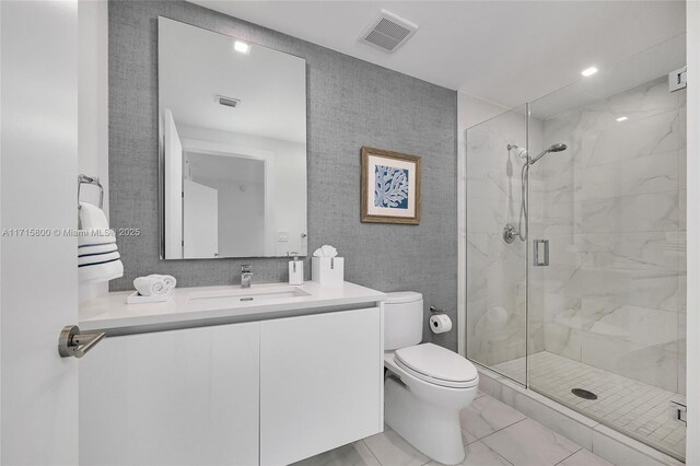 bathroom featuring tile patterned flooring, a shower with door, vanity, and toilet