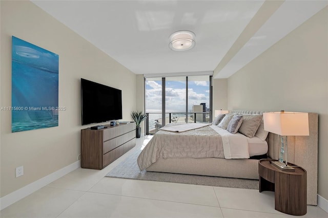 bedroom with expansive windows, access to outside, and light tile patterned floors