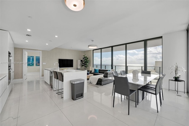 dining space featuring sink and floor to ceiling windows