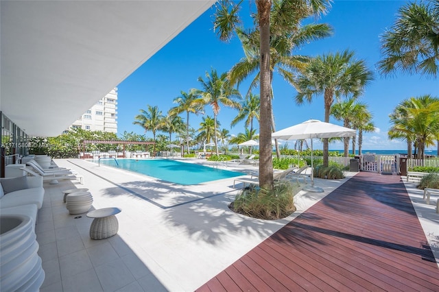 view of pool with a water view and a patio