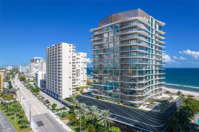 view of building exterior with a beach view and a water view