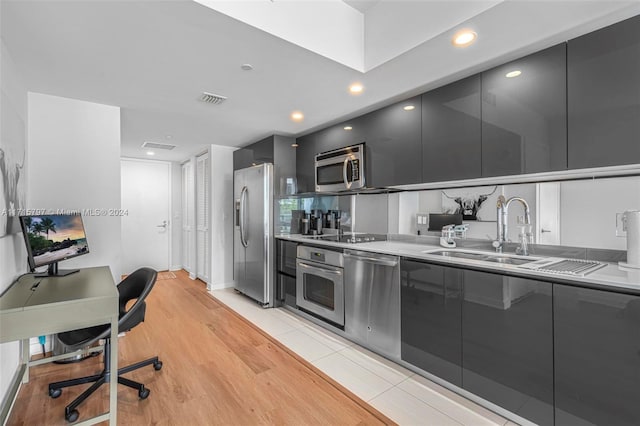 kitchen with light wood-type flooring, sink, and appliances with stainless steel finishes