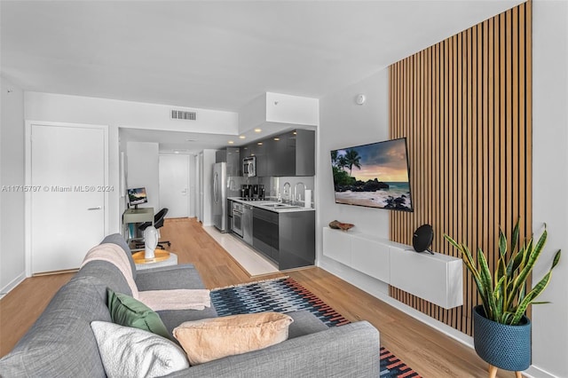 living room with sink and light wood-type flooring