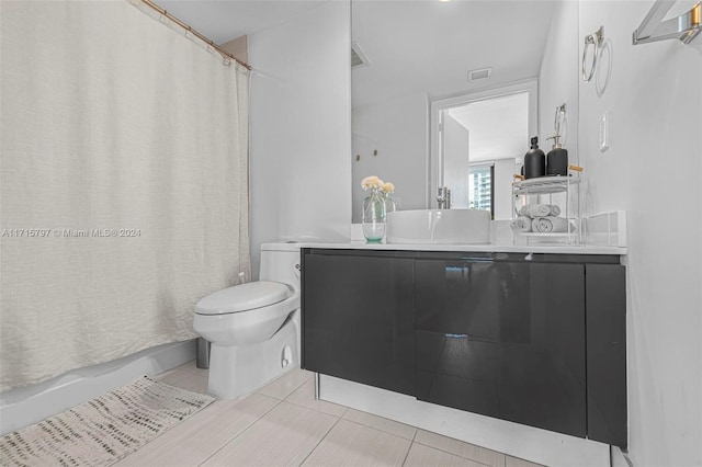 full bathroom featuring tile patterned floors, vanity, toilet, and shower / tub combo with curtain