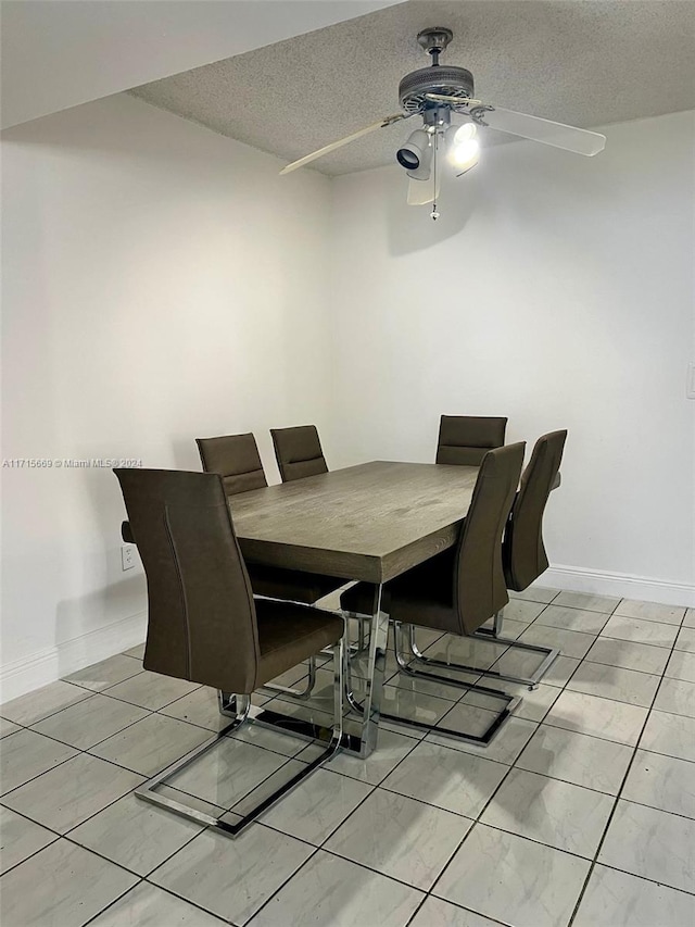 tiled dining room with ceiling fan and a textured ceiling