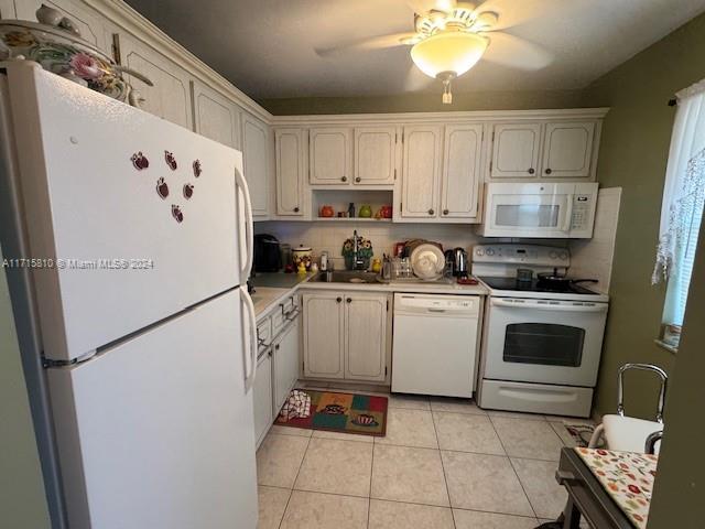 kitchen featuring ceiling fan, white appliances, sink, and light tile patterned floors