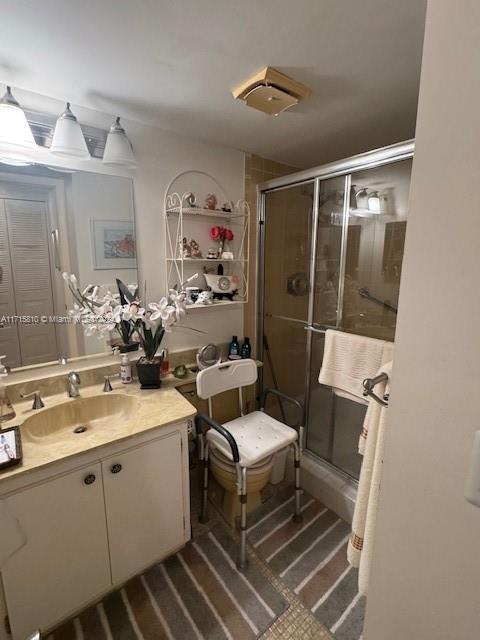 bathroom with vanity and a shower with shower door