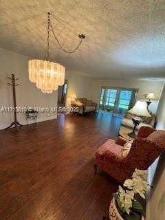 7500 NW 5th Pl Unit 103, Margate, FL 33063 - living area featuring wood finished floors, a chandelier, and a textured ceiling