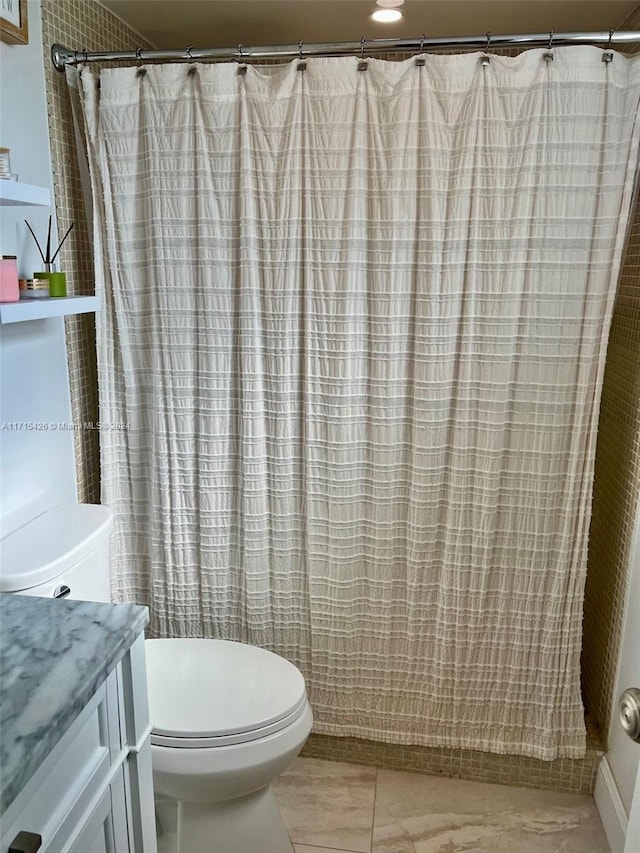 bathroom featuring vanity, curtained shower, and toilet