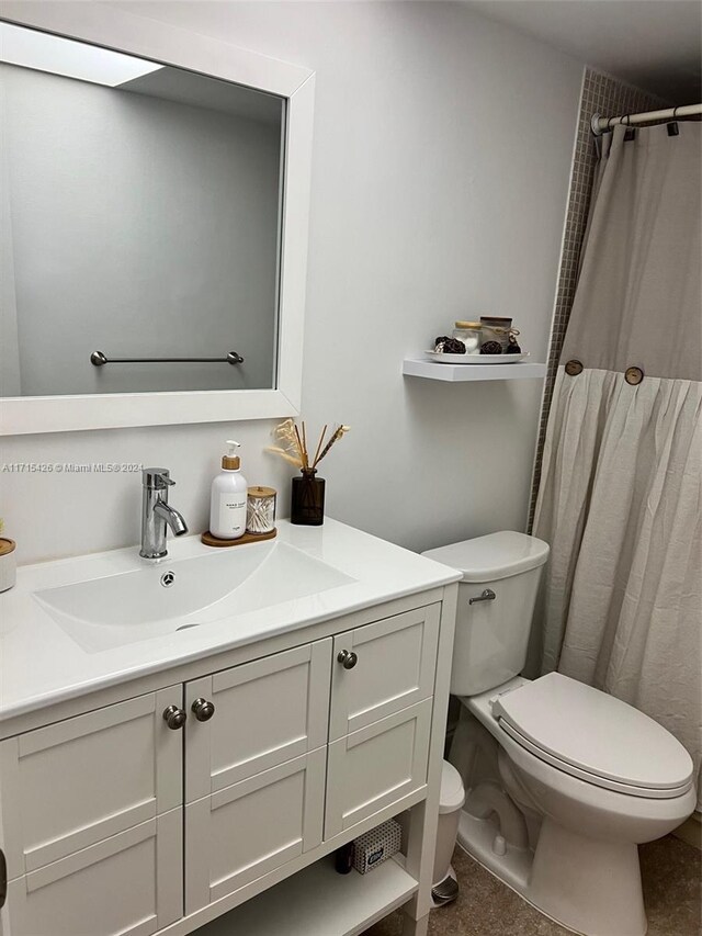 bathroom featuring tile patterned flooring, vanity, toilet, and curtained shower