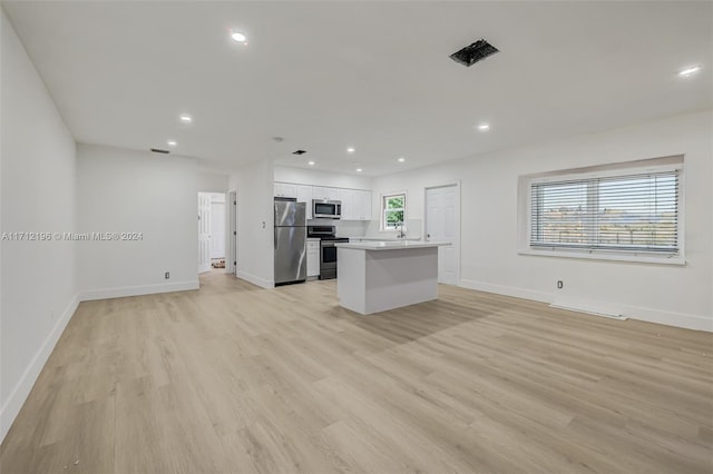 kitchen featuring white cabinets, a center island, light hardwood / wood-style floors, and appliances with stainless steel finishes