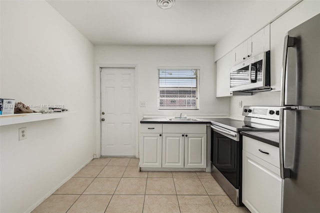 kitchen featuring light tile patterned floors, stainless steel appliances, white cabinetry, and sink