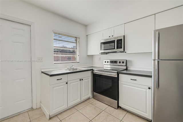 kitchen featuring sink, white cabinets, stainless steel appliances, and light tile patterned floors