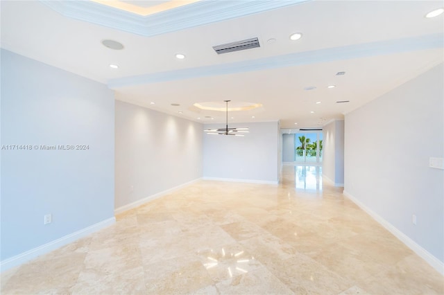 empty room with a raised ceiling and crown molding