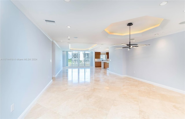 unfurnished room featuring an inviting chandelier, crown molding, and a tray ceiling