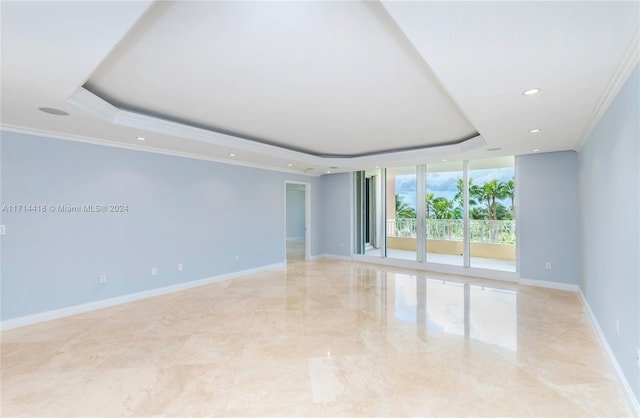 unfurnished room with a tray ceiling and ornamental molding