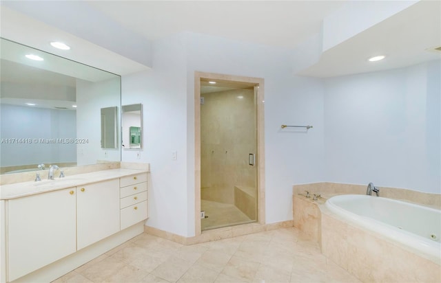 bathroom featuring tile patterned flooring, vanity, and separate shower and tub