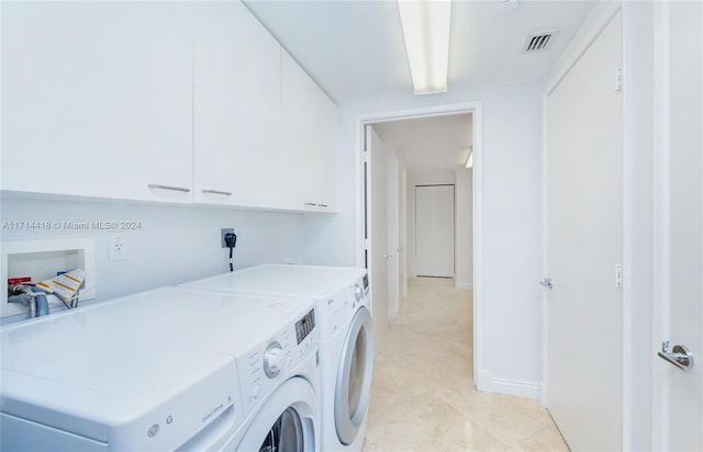 washroom featuring washing machine and dryer and cabinets