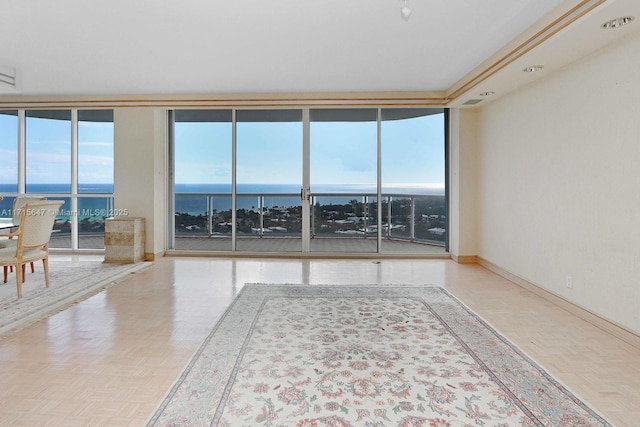 unfurnished room with expansive windows, a water view, and parquet floors