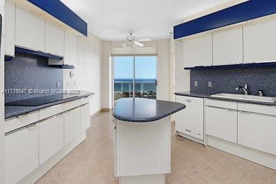 kitchen with white cabinets, ceiling fan, dishwasher, and sink