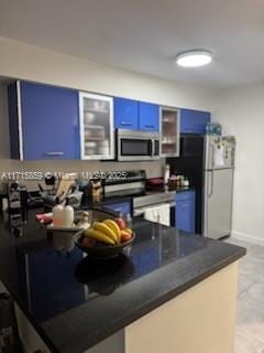 kitchen with appliances with stainless steel finishes, kitchen peninsula, and blue cabinets