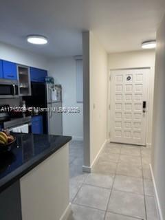 kitchen featuring blue cabinets, a mail area, range with electric stovetop, and light tile patterned floors