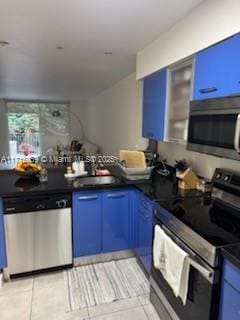 kitchen with blue cabinets, appliances with stainless steel finishes, sink, and light tile patterned floors