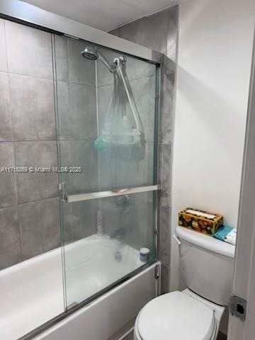 bathroom with enclosed tub / shower combo and toilet