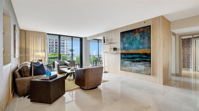 tiled living room featuring a wall of windows