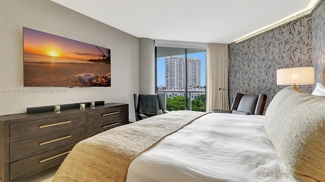 bedroom featuring expansive windows and access to outside