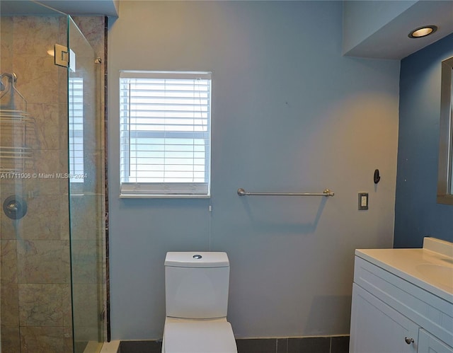 bathroom featuring vanity, toilet, and a shower with shower door