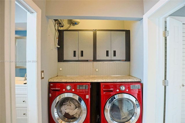 laundry room featuring cabinets, sink, and washing machine and clothes dryer