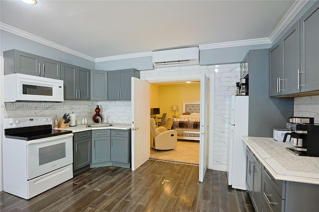 kitchen featuring dark hardwood / wood-style floors, backsplash, a wall mounted AC, crown molding, and white appliances