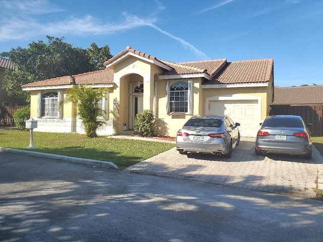 mediterranean / spanish house with a front yard and a garage