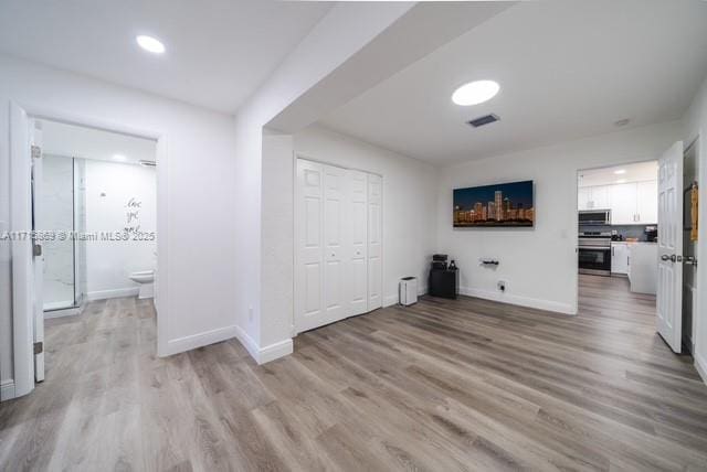 hallway with light hardwood / wood-style floors