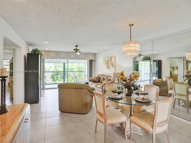 dining area featuring a textured ceiling, light tile patterned floors, and ceiling fan with notable chandelier