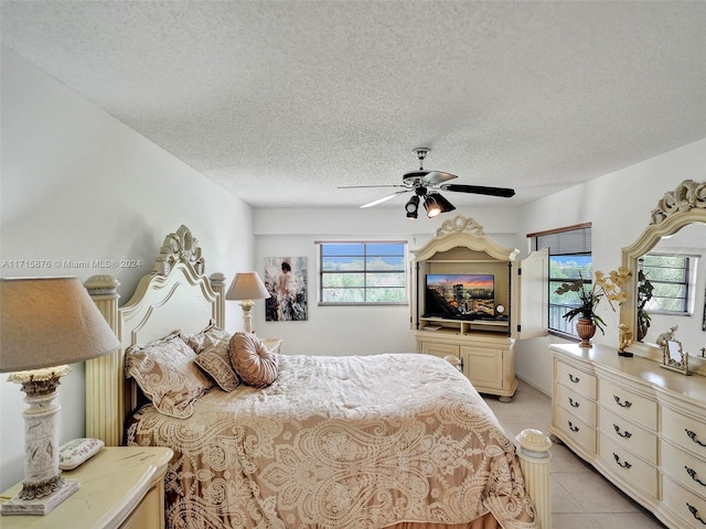 tiled bedroom featuring a textured ceiling and ceiling fan