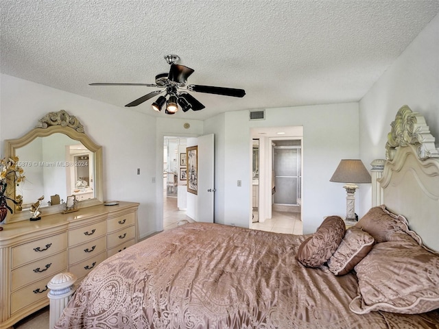 tiled bedroom featuring ceiling fan, a closet, a spacious closet, and a textured ceiling