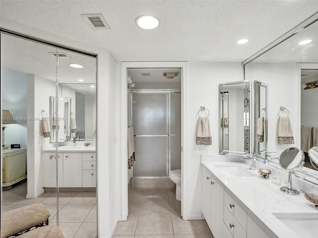 bathroom with tile patterned floors, vanity, and a textured ceiling