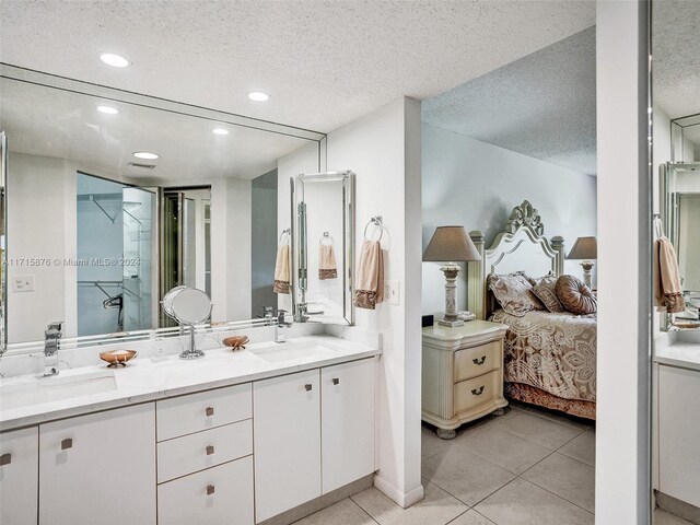 bathroom with tile patterned floors, vanity, and a textured ceiling