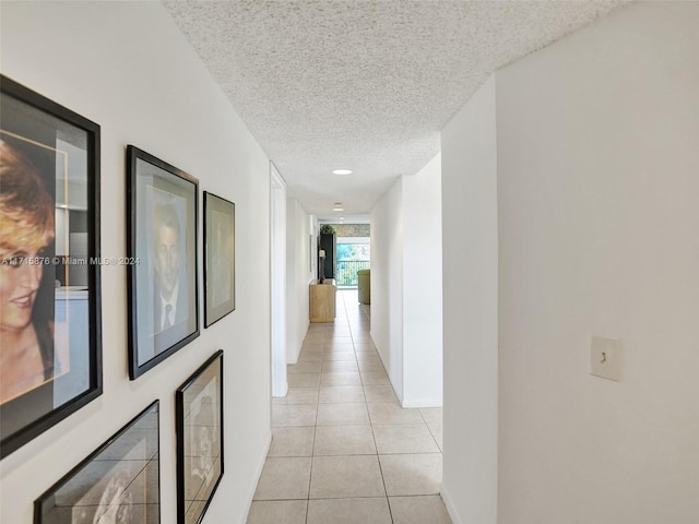 hall with light tile patterned floors and a textured ceiling