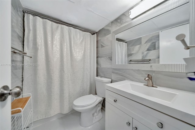 bathroom with tile patterned flooring, tile walls, curtained shower, toilet, and vanity