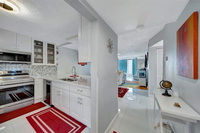 kitchen featuring sink, stainless steel appliances, white cabinetry, and tasteful backsplash