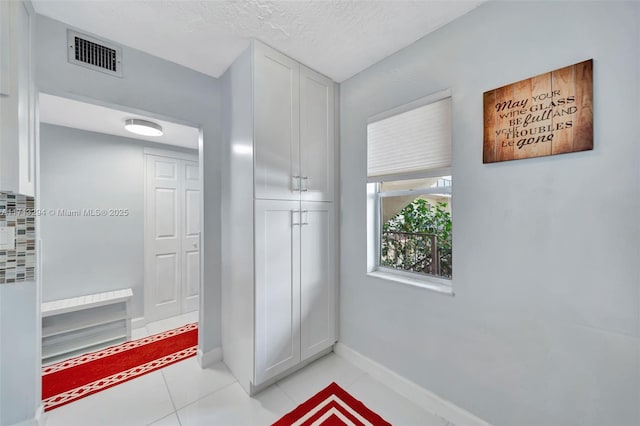 interior space featuring a textured ceiling and light tile patterned flooring