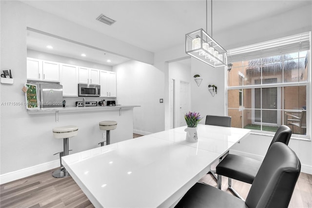 dining area featuring light wood-type flooring