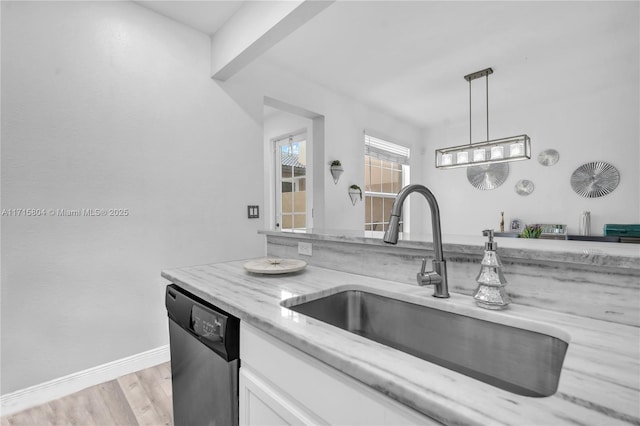 kitchen with dishwasher, sink, hanging light fixtures, light hardwood / wood-style flooring, and white cabinets