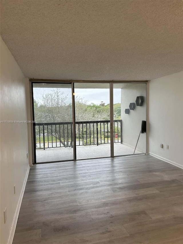 spare room with a wealth of natural light, expansive windows, and a textured ceiling