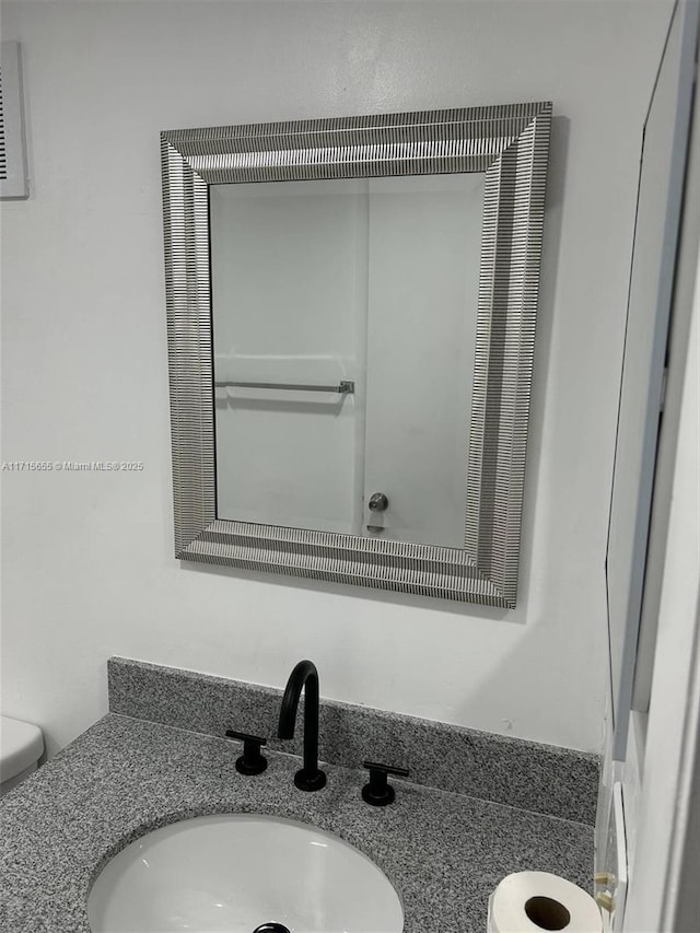 bathroom featuring toilet and vanity