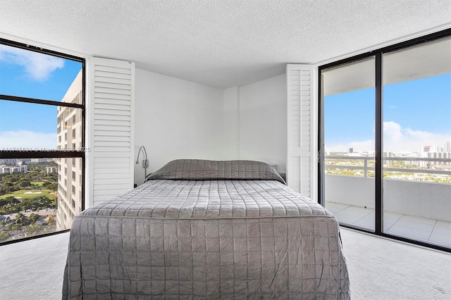 carpeted bedroom featuring expansive windows and a textured ceiling